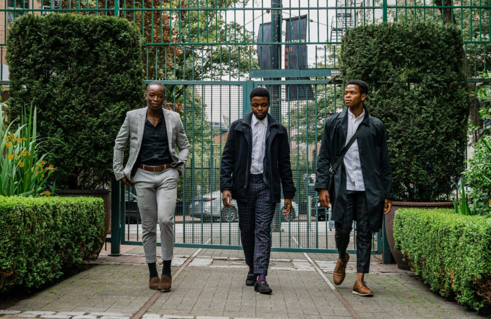 Three Black men walking together in an urban setting